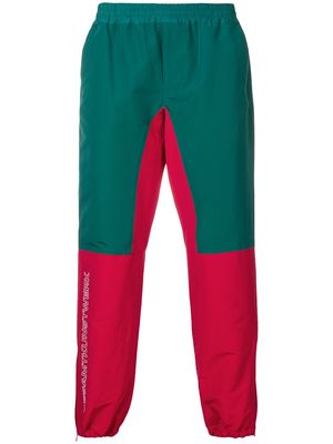 JohnUNDERCOVER colour-block track trousers - Green