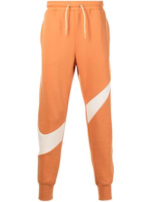 Nike swoosh-print fleece track pants - Orange
