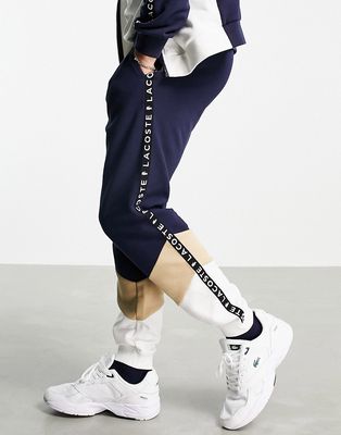 Lacoste color block zip through taped sweatpants in navy/stone