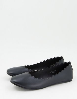 Accessorize flat shoes with scallop detail in black