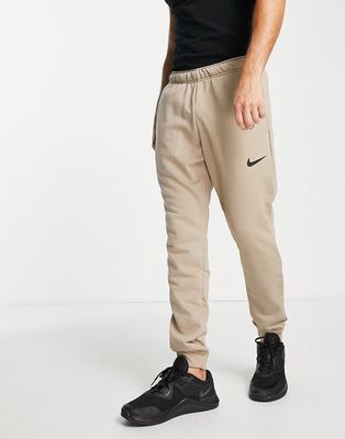 Nike Training Dri-FIT Swoosh cuffed fleece sweatpants in dark sand-White