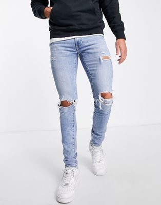 Levi's skinny taper jeans in light blue wash with knee rips