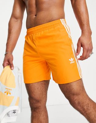 adidas Originals adicolor three stripe swim shorts in orange
