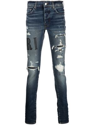 AMIRI distressed logo-print skinny jeans - Blue