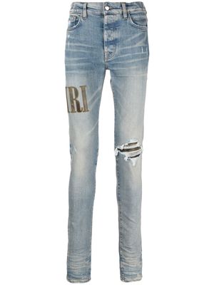 AMIRI logo-embroidered ripped-detail jeans - Blue