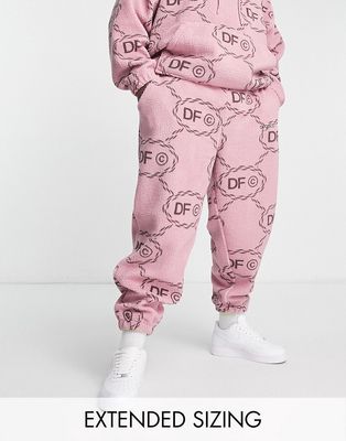 ASOS Dark Future relaxed joggers in teddy with all over monogram logo print and embroidery in pink - part of a set