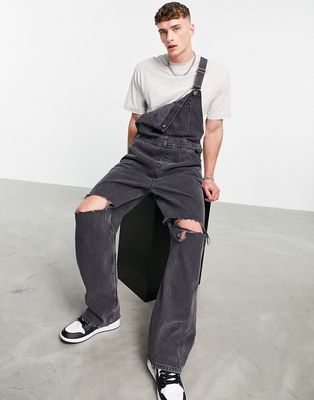 ASOS DESIGN baggy denim overalls in washed black with knee rips
