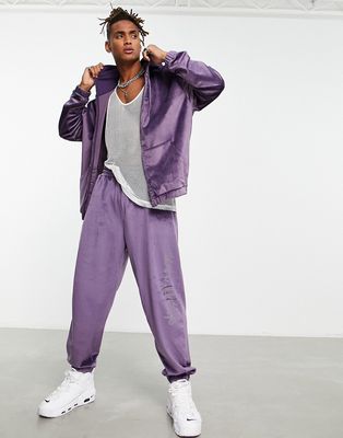 ASOS DESIGN oversized velour sweatpants with diamante text detail in purple