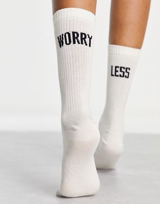 ASOS DESIGN socks with worry less slogan in off white
