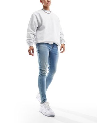 ASOS DESIGN spray on jeans in tinted light blue