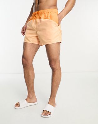 ASOS DESIGN swim shorts in short length with cut-and-sew in orange