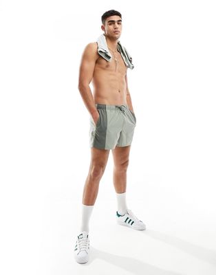 ASOS DESIGN swim shorts in short length with tonal panel design in khaki-Green