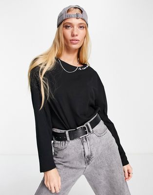 Calvin Klein Jeans logo long sleeve high low hem top in black