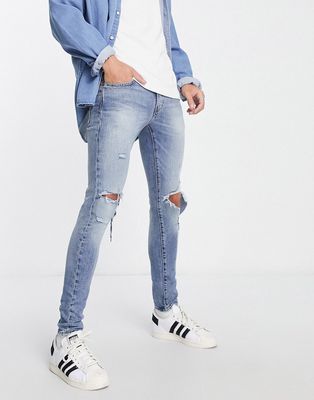 Levi's skinny taper fit jeans with rips in light wash blue
