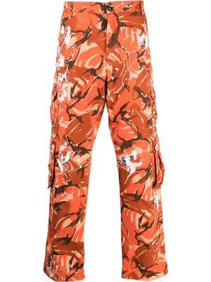 Martine Rose paint splatter camouflage-print trousers - Orange