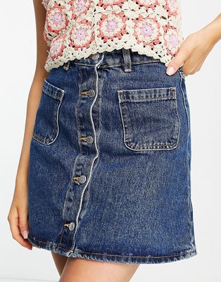 Monki button through mini skirt with front pockets in mid wash denim-Blue