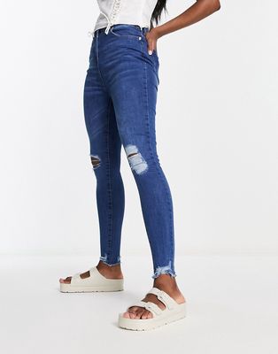 Parisian skinny jeans with distressed knee in mid blue